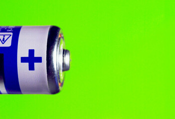 plus symbol on lithium battery AA on bright green background