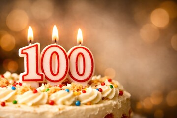 A cake with three candles on it with the number 100 written on it