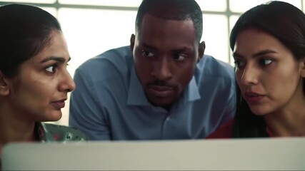 A group of diverse colleagues intently focused on a computer screen, engaged in a collaborative effort, their expressions conveying interest and concentration