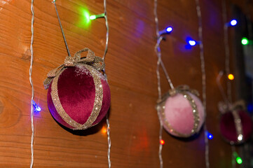 Christmas decorations. Handmade neon balls hang on the wall.