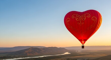 Fototapeta premium Red Heart Shaped Hot Air Balloon Flying Over River Valley at Sunset Sunrise