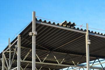 Obraz premium Steel building roof structure during construction with metal beams and corrugated roofing sheets
