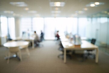 Blurred modern open office with desks and workers