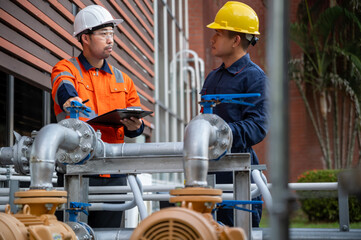 Two engineers are inspecting high-pressure water pipes and checking the integrity of the equipment