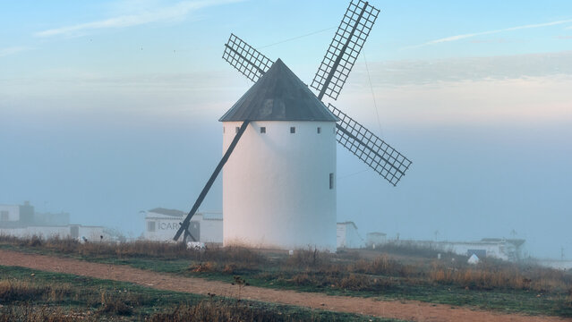 Don Quichote Windmill La Mancha on a hill side, arising from the morning mist bank at sunrise in Campo de Criptana Castilla La Mancha Spain