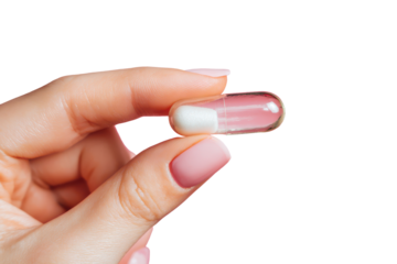 Hand holding a clear capsule with white powder against a pink background in a simple setting
