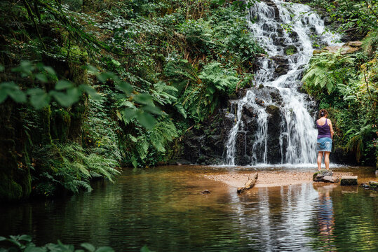 Femme &agrave; la cascade de Faymont dans les Vosges. Femme dans une chute d'eau dans une for&ecirc;t en &eacute;t&eacute;. 