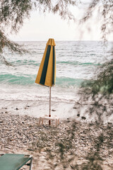 Ombrellone chiuso tra le frasche su spiaggia di Skopelos in Grecia