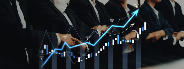 Business professionals discuss financial trends and analyze data in a modern office setting, with graphs and charts illustrating growth and success strategies. Scalp
