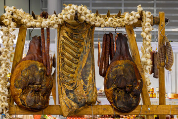 Cured pork meat hanging inside smokehouse ready for smoking