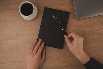 A clean and inviting workspace features a laptop, a coffee cup, and a notebook, creating an ideal environment for studying at home. The warm wood surface enhances focus and comfort