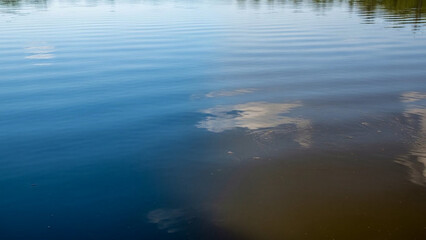 Lake surface transitioning from clean to polluted abstract style (symbolic, non-graphic).