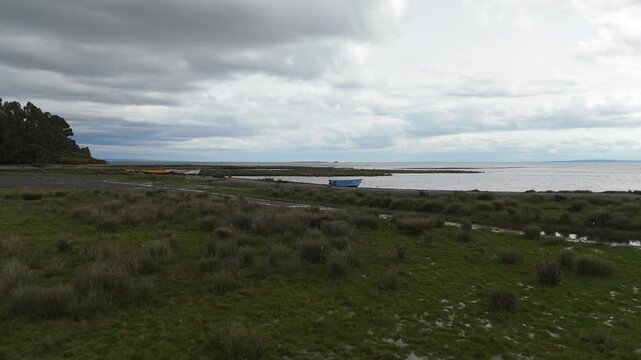 Aerial Very Low Flight Over Coastal Wetlands Towards Colorful Wooden Boats