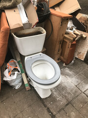 An old discarded toilet at a garbage dump
