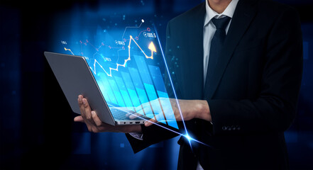 A businessman engages with a laptop displaying graphs and charts, symbolizing financial analysis and growth in a modern business environment. Scalp