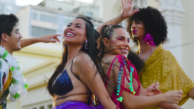 Fun people dancing at Carnival Party. Friends in celebration of brazilian Carnaval outdoors in costume