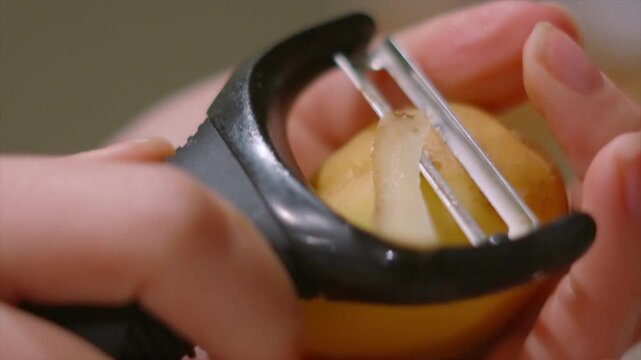 Raw Maris Piper Potato Being Peeled in Slow Motion. Vegetable Being Prepared for Cooking.