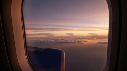 View from airplane window of beautiful sunset sky over clouds. Aerial landscape at dawn or dusk for travel and freedom concept. Stunning natural light.