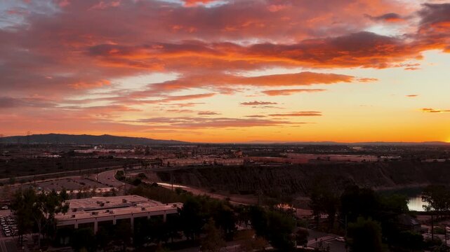 Aerial footage of a lake surrounded by homes and lush green trees at sunset in Duarte California USA