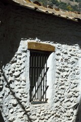Ventana con reja en una pared encalada blanca en Pampaneira, Alpujarra de Granada, Andaluc&iacute;a, Espa&ntilde;a
