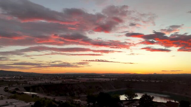 Aerial footage of a lake surrounded by homes and lush green trees at sunset in Duarte California USA