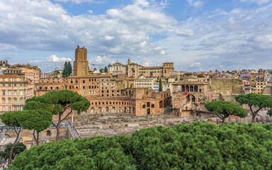 Fototapeta premium Rome, Italy. Panoramic view of ancient Roman ruins and historic buildings, showcasing lush greenery and vibrant city life with dramatic clouds overhead