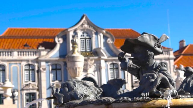 Playful monkey fountain sculpture in sharp focus with palace softly blurred behind it, sunny day and clear blue sky, no people visible