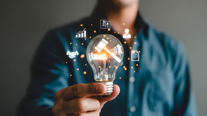 Man holding a glowing lightbulb featuring digital law and justice icons, concept of legal advice, gavel, and intellectual property rights..png