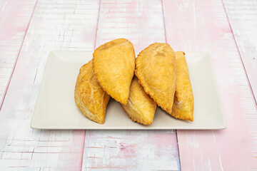 Classic cod empanadas, fried until crispy on the outside, served on paper towels to absorb the excess oil