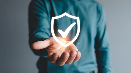 Protecting digital information concept with a hand holding a glowing shield and checkmark symbol representing verified cybersecurity..png