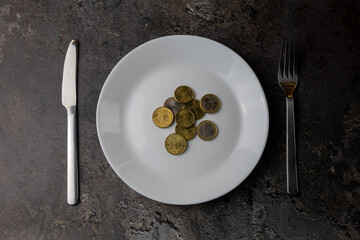 Coins On Empty Plate With Cutlery