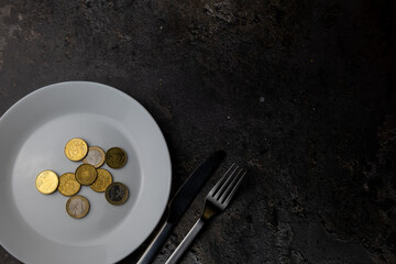 Coins On Empty Plate With Cutlery