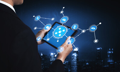 A business professional interacts with a digital tablet showcasing social networking icons against an abstract technology backdrop, emphasizing innovation and connectivity. Tessel