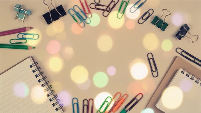 Overhead view of office supplies scattered around a bokeh light background stationery desk