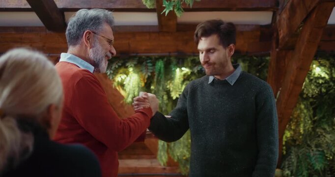 Therapist offers a supportive hand to insecure participant after his speech  during group psychotherapy, showing reassurance, trust, and professional emotional support.