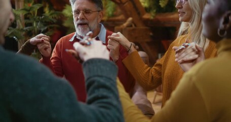 Therapist guiding group through breathing and relaxation exercise, participants holding hands in a circle with eyes closed, focusing on calm breathing and emotional grounding in supportive environment