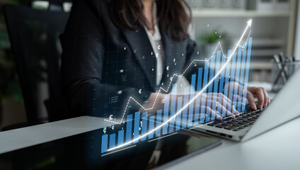 A professional woman in a suit engages with financial data on her laptop, highlighting trends and...