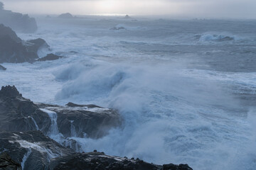 Fototapeta premium Crashing waves and sun highlighting the horizon