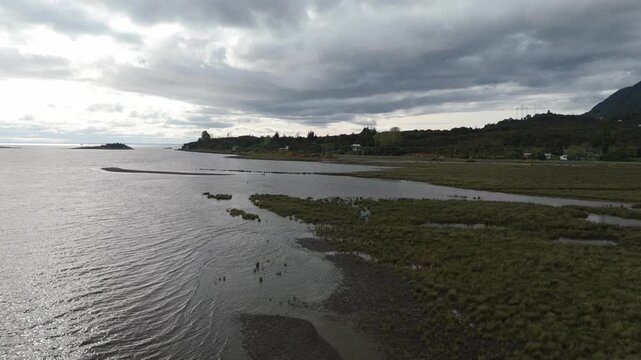 Aerial View of Coastal Shoreline Under Powerful Low Hanging Clouds