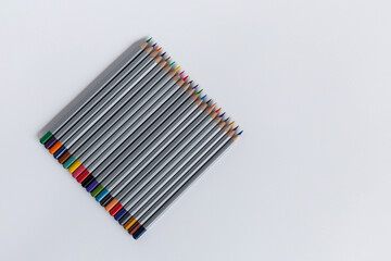 Pencils laid out in a row on a gray background