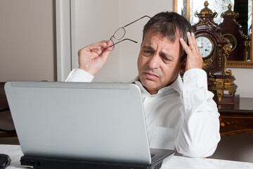 Stressed Middle-Aged Man Working on Laptop at Home Office