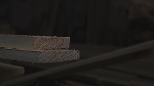 Subdued Lighting Highlights Textured Grain And Vintage Patina On Stacked Wooden Boards In Quiet Storage. Media