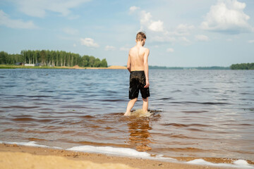 Boy Strolling Through Water on a Sunny Day at the Lake