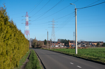 Renovated asphalt road with power lines, telephone cables, and residential houses in Ans