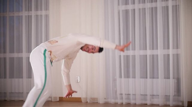 Martial arts. Capoeira. A professional emotional man performs a turnovers leaning on hands