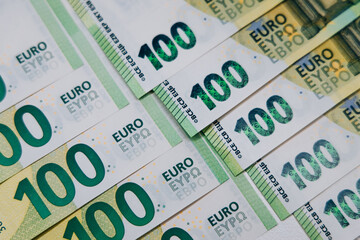 Close-up view of multiple hundred euro banknotes arranged in a fan shape, showcasing intricate designs and vibrant colors, representing currency and financial transactions
