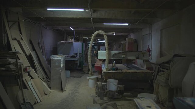 Workshop Cluttered With Equipment And Dust, Crowded Timber Shop Filled With Machinery And Shadows. Media