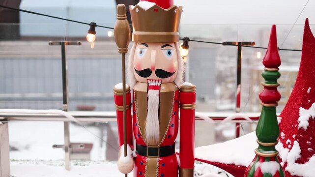 Outdoor terrace with large nutcrackers, festive decorations and decorated Christmas tree with toys balls and red stars. Beautiful interior balcony of the house on holiday winter and New Year. 