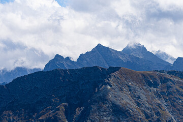 Mountain peak emerging through clouds with dramatic alpine atmosphere