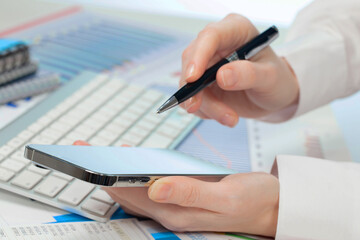 A woman working on an accounting report with a computer. Close-up of her hands.